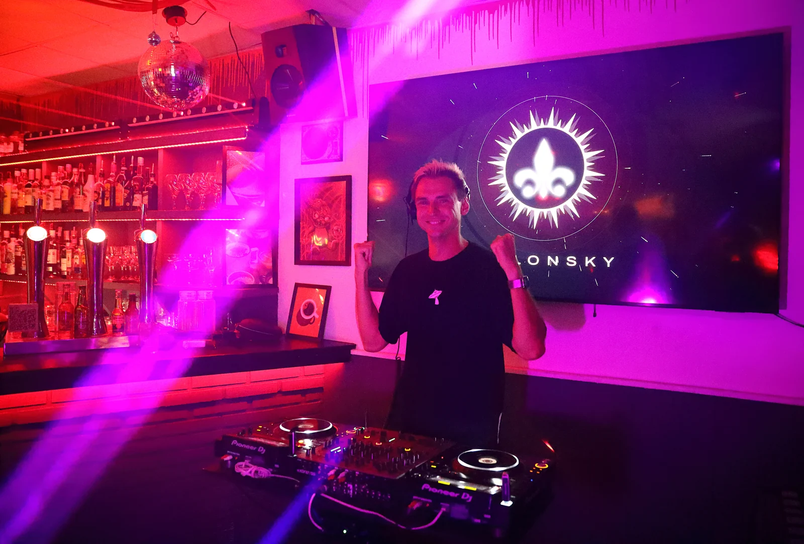 SOLONSKY in a DJ booth surrounded by violet light